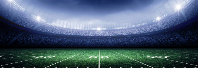 Nighttime photo of a foodball stadium from the perspective of the 50 yard line, looking up at the sky.